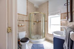 een badkamer met een douche, een toilet en een wastafel bij East Village Townhouse in New York