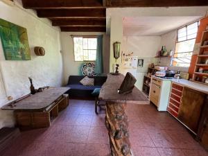 a kitchen with a table and a couch in a room at Habitación con baño privado y cama doble in Piriápolis