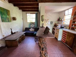 una cucina con un tavolo e un divano in una stanza di Habitación con baño privado y cama doble a Piriápolis