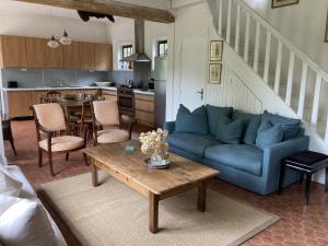a living room with a blue couch and a table at Clos Normand in Varengeville-sur-Mer