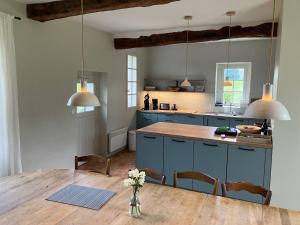 a kitchen with blue cabinets and a wooden table at Chaumiere Bleue in Saint-Pierre-le-Vieux