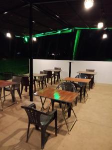 um grupo de mesas e cadeiras com luzes verdes em The Cool Huts em Mandrem