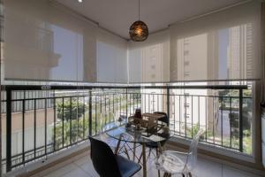 Cette chambre dispose d'un balcon avec une table et des chaises en verre. dans l'établissement Apartamento 408 em condomínio de alto padrão, à Guarulhos