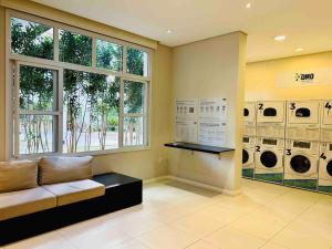 a laundry room with a couch and multiple washing machines at 0408 - Studio Essenza Maia - Conforto Refinado in Guarulhos