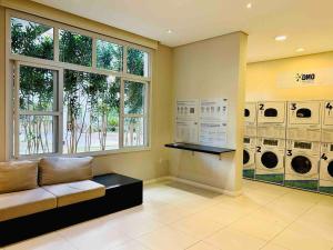 a laundry room with a couch and multiple washing machines at Apartamento 408 em condomínio de alto padrão in Guarulhos