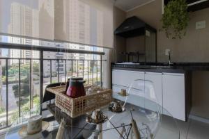 a kitchen with a glass table and a window at Apartamento 408 em condomínio de alto padrão in Guarulhos
