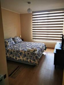 a bedroom with a bed and a large window at costanera playa villarrica in Villarrica