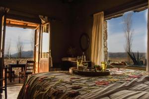 Un dormitorio con una cama con una mesa con flores. en Posada Punta de Piedra en La Cumbre