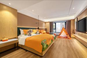 a bedroom with a large bed and a flat screen tv at Atour X Hotel Harbin West Railway Station in Harbin