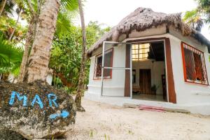 a small house with a thatch roof at Playa Lakin-ha beachfront cabins in Tulum