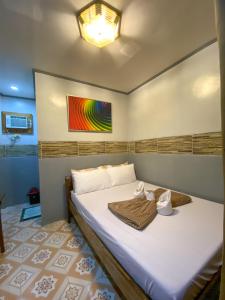 een slaapkamer met een bed met een schilderij aan de muur bij BILLY'S TOURIST INN in El Nido