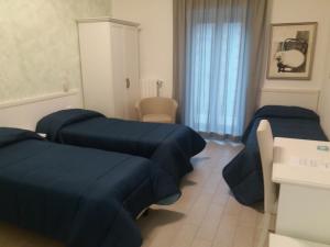 2 letti in una camera con lenzuola blu sopra di Hotel Costa a Bari
