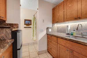 a kitchen with wooden cabinets and a sink at Kona Islander Inn 147 Tropical Oasis in Kailua-Kona
