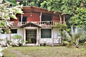 a red and white house with a balcony at Itapoa Reserve in Puerto Quito