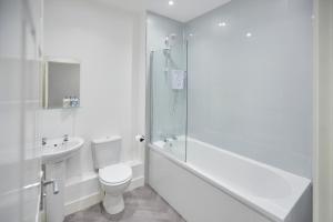 a white bathroom with a toilet and a sink at Host & Stay - Loftus Apartments in Loftus