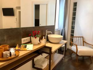 a bathroom with a counter with a sink and a mirror at DIMOR'A' ROOMS in Pitigliano