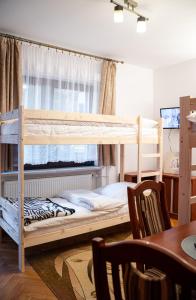 a bedroom with two bunk beds and a table at Hostel Wielka Krokiew in Zakopane