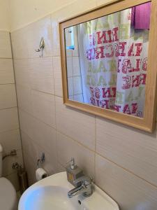 a bathroom with a sink and a mirror and a toilet at Traditional villa KALAMPAKA 