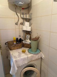 a bathroom with a toilet with a table and towels at Traditional villa KALAMPAKA 