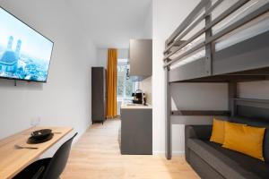 a living room with a couch and a loft bed at Servus Apartments by Homaris in Munich