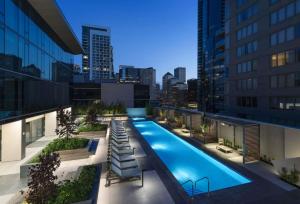 a swimming pool on the roof of a building with a city skyline at Rincon Hill 1BR w WD Gym Pool nr Tech HQs SFO-778 in San Francisco