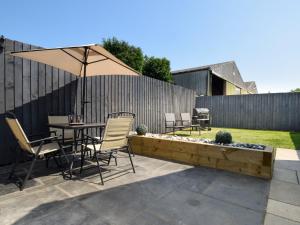 a patio with a table and chairs and an umbrella at 2 bed property in Howden 86817 in Scalby