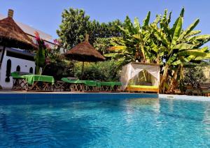 a pool with chairs and umbrellas next to a house at Ginger Villa Somone in Somone