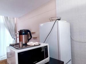 eine Mikrowelle mit einer Kaffeekanne darauf neben einem Kühlschrank in der Unterkunft New Apartment 3mins walk to shops in Harare + 5 Fotos