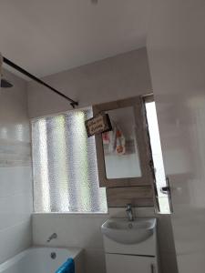 ein Badezimmer mit Waschbecken und Toilette und einem Fenster in der Unterkunft New Apartment 3mins walk to shops in Harare