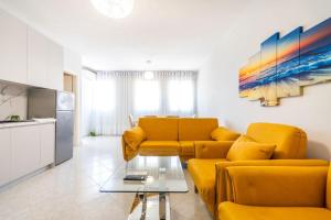a living room with a yellow couch and a table at Old Beach Apartments in Vlorë