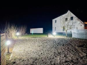 Cosy holiday home HELMA directly at the Baltic Sea في زيروف: حظيرة بيضاء في الليل مع أضواء أمامه