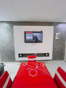 een rode loper met rode stoelen en een flatscreen-tv bij appartement dino in Marrakesh