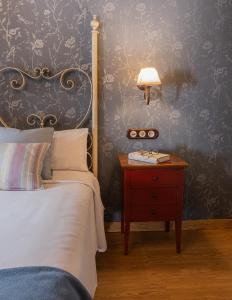 a bedroom with a bed and a table with a lamp at El Acebo in Hervás