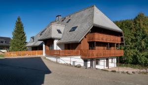 uma grande casa de madeira com um grande deque em Tannenhof Fischbach - Fewo 3 "Bachforelle" - Schluchsee, 1 Schlafzimmer em Schluchsee