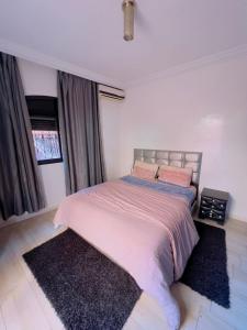 een slaapkamer met een groot bed met 2 kussens bij appartement dino in Marrakesh