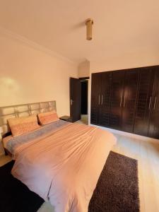 1 dormitorio con 1 cama grande y armarios negros en appartement dino, en Marrakech