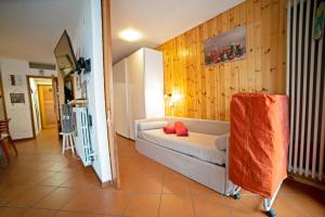 - un salon avec un canapé blanc et des murs en bois dans l'établissement Le Nasse, à San Martino di Castrozza