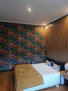 1 dormitorio con 1 cama grande y papel pintado con motivos florales en Fridda House Oviedo Hospital, en Oviedo