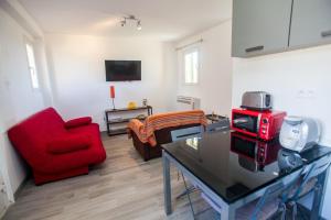 un soggiorno con divano rosso e sedia rossa di Appartement résidence avec piscine a Calvi