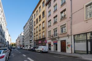 uma rua da cidade com carros estacionados ao lado de edifícios em Alma - Charmant apt 2 chambres em Lyon