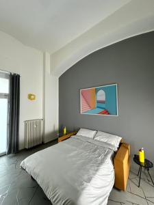 a bedroom with a large bed with a painting on the wall at Casa Genovesi - vicino Porta Nuova F.S. in Turin