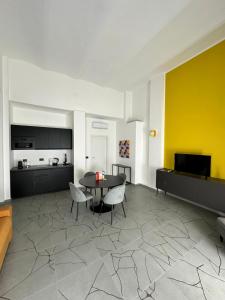 sala de estar con mesa, sillas y pared amarilla en Casa Genovesi - vicino Porta Nuova F.S. en Turín