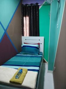 um pequeno quarto com uma cama azul e verde em Sharaf DG Partition Private room 40 flat 03# em Dubai