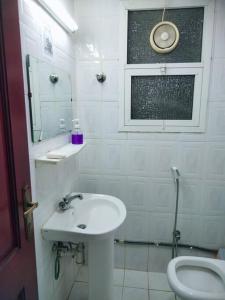 uma casa de banho branca com um lavatório e um WC em Sharaf DG Partition Private room 40 flat 03# em Dubai