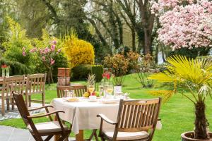 a table in a garden with a white table cloth at ArtVilla am See - buchbar April-Mai 2024 in Radolfzell am Bodensee