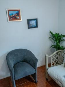 una silla azul y una planta en una habitación en Las Casitas en Salinas en Salinas