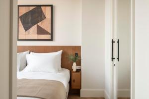 ein Schlafzimmer mit einem Bett neben einer Tür in der Unterkunft The Onsider - Luxury Apartment 3 Bedrooms - Paseo de Gracia in Barcelona