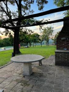 un banco de piedra en un parque con un árbol en Homestay Victoria Entre Rios en Victoria