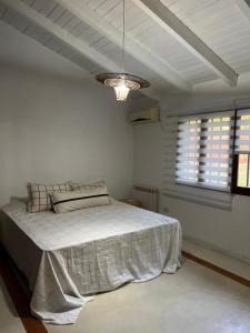 Dormitorio blanco con cama y techo en Homestay Victoria Entre Rios, en Victoria
