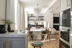 eine Küche und ein Wohnzimmer mit einem Tisch und Stühlen in der Unterkunft The Onsider - Penthouse 3 Bedroom Apartment - Paseo de Gracia in Barcelona